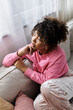 © LIGHTFIELD STUDIOS - Elegant young African American woman enjoying a moment of thought at home in cozy surroundings
