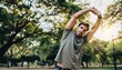© meka - Man stretching arms overhead in park during morning workout.