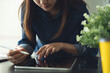 © tippapatt - Business woman using digital tablet and laptop working at office, reading and proofing e-document via mobile app