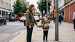 © Bruno Stock - Mother and daughter at a pedestrian crossing pressing the button to cross the street in a busy city