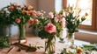 © Wuttichai - A wooden table displays several glass vases filled with pink and white flowers  surrounded by greenery and floral tools under soft natural light