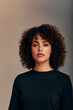 © overrust - confident woman with natural curly hair, focused expression and soft lighting, expressive portrait of a woman with natural curls and an attentive intelligent gaze