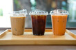 © Dontree - Iced espresso coffee, iced Americano and an iced Thai milk tea in plastic glass served on wood tray, summer drink concept