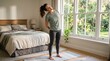 © phj.domingos - Woman stretching her neck and torso while standing on a yoga mat in her bedroom