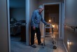 © Kassiopeia  - An older man in pajamas uses a walker while moving through a dimly lit hallway in his home at night. He is near a bedroom and a bathroom, navigating slowly