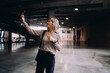 © BullRun - Cheerful mature Caucasian woman posing for selfie with smartphone in empty hall, female professional recording video message or stories, digital communication and content creation.
