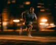 © Anuson - Man running at night with blurred lights in the background creating motion effect