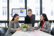 © David - Three asian businesswomen working together on a laptop and documents, discussing financial reports and strategy in a contemporary workspace, fostering teamwork and professional development