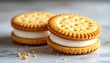 © Chandlerlikes - Two golden sandwich cookies with smooth white cream filling, appetizing dessert product photography