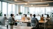 © Panuwat - Modern office space with people working at desks and computers in a blurred view.