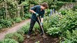 © Pris - Young man with gardening fork digging soil in a lush flower garden with roses and delphiniums