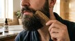 © Dara - A man with a beard using a wooden comb to groom his facial hair.