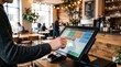 © Ran - Modern cafe owner using digital POS tablet system for customer payment processing, small business retail technology, touchscreen interface in coffee shop environment