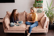 © Tatyana Gladskih - Woman talking with teenage daughter sitting on sofa at home. Mother and girl having conversation in living room. Family communication and parenting support concept.