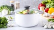 © dvoevnore - White pot with mixed vegetables in modern kitchen setting, cooking concept