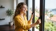 © Len_mik - Smiling young woman opening a window to a scenic coastal view. Happy teenage girl letting fresh air into her room. Travel and healthy lifestyle concept