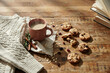 © iqrastockwork - Freshly baked chocolate chip cookies arranged on a rustic wooden table with hot drink