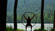 © OlTarakanov - Sequential shot of a young man relaxing on a round ring swing and raising his hands to grab the edge while looking at the majestic Siberian mountains.
