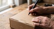 © Katsiaryna - Closeup of hands writing address on cardboard parcel with permanent marker near window