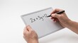 © SeoBraga - Person's hands holding a whiteboard with a mathematical equation written on it