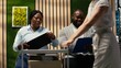 © DC Studio - Businesswoman secretary walks with a trolley cart and gives files and corporate registration forms to people sitting in a hallway line while candidates prepare for career opportunities.