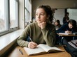 © Gerald UK - Young student girl daydreaming in classroom looking out window during lesson.