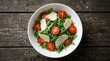© Masque - Fresh arugula salad with cherry tomatoes and parmesan cheese in a white bowl.