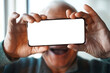© Westend61 - Cheerful senior man holds a smartphone with a blank mockup screen