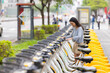 © leungchopan - Woman renting public bicycle at station in city