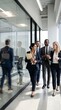 © Almas Ikhwan - Diverse Group of Professional Business Colleagues Walking and Talking Together in a Modern Corporate Office Hallway