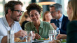 © Nataliya - Business employees sharing food and conversation during lunch in a bright modern office cafeteria, corporate culture, workplace communication, teamwork, employee wellbeing, with