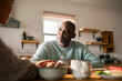 © Marko Geber - Mature man comforting partner at home kitchen table