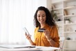 © Prostock-studio - Smiling Young Woman Holding Smartphone And Credit Card While Making Online Purchase At Her Modern Office Desk. Engaged In Shopping With Positive Emotion, Enjoying Convenient Payment Method.