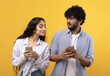 © Prostock-studio - Smiling Young Asian Woman And Man Engaged With Smartphones, Enjoying Moment With Each Other While Standing Together In Bright Yellow Background. Perfect For Technology And Communication Concept.