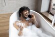 © Prostock-studio - Smiling Young South Asian Man Enjoying Relaxation In Bathtub Full Of Bubbles, Talking On Phone At Home, Feeling Comfortable And Happy During Self-care Routine, Home Spa Concept.