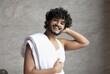 © Prostock-studio - Happy Young Male With Curly Hair Smiling While Holding Towel, Standing Indoors. Radiating Joy At Home, Engaging In Self-care Routine Is Vital For Overall Wellbeing And Confidence.
