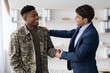 © Prostock-studio - Smiling Black Male Soldier Engaging In Friendly Handshake With Businessman In Modern Office Environment, Displaying Professionalism And Positivity. Business Concept.