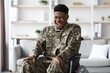 © Prostock-studio - Smiling Black Man In Military Uniform Sitting In Wheelchair At Home, Expressing Joyful Emotion. This Scene Represents Courage And Resilience In A Comfortable Indoor Setting. Healthcare Concept.