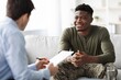 © Prostock-studio - Smiling Black Male Client Engaged In Conversation With Therapist At Office, Discussing Personal Issues And Emotions, Creating A Supportive Environment In A Professional Setting. Healthcare Concept.