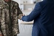 © Prostock-studio - Focused Black Male Soldier In Uniform Shaking Hands With Caucasian Male Businessman In Office Setting, Demonstrating Professional Cooperation And Collaboration For Future Endeavors. Business Concept.