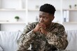 © Prostock-studio - Worried Black Male Soldier Sitting With Hands On Chin, Reflecting On Stress And Challenges During Service, At Comforting Modern Living Room Setting, Emphasizing Mental Health Concept.