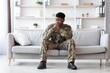© Prostock-studio - Worried Black Male Soldier In Military Uniform Sitting Thoughtfully On Couch At Home, Reflecting On Experiences And Emotions, Creating A Sense Of Calmness And Introspection. Military Concept.