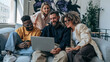 © pattozher - Collaborative Spirit: A group of diverse colleagues collaborates enthusiastically around a laptop, sharing ideas and insights in a modern, casual workspace.