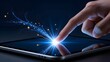© Sidiq Hariadi Diang - Human index finger interacting with dark reflective tablet surface generating curving trail of magical blue stardust and glowing electronic data transmission.