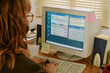 © AnnaStills - Over shoulder view of Caucasian young adult woman typing on keyboard in retro office, working on old computer. Image represents vintage technology and nostalgia in corporate marketing