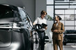 © wedmoments.stock - Sales consultant and woman discussing a new car during a dealership consultation. Concept vehicle purchase, customer care and automotive business.