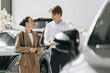 © wedmoments.stock - Female buyer receiving professional advice from a car dealer while selecting a new vehicle.