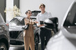 © wedmoments.stock - Female buyer discussing vehicle features with a dealership representative while choosing a car.
