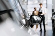 © wedmoments.stock - Man consulting a woman about a new vehicle during the car selection process.