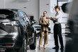 © wedmoments.stock - Female buyer receiving information about a new vehicle. Concept sales, leasing, financing and customer service.